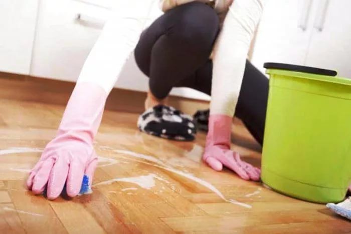 Cleaning primer from linoleum with an abrasive sponge.