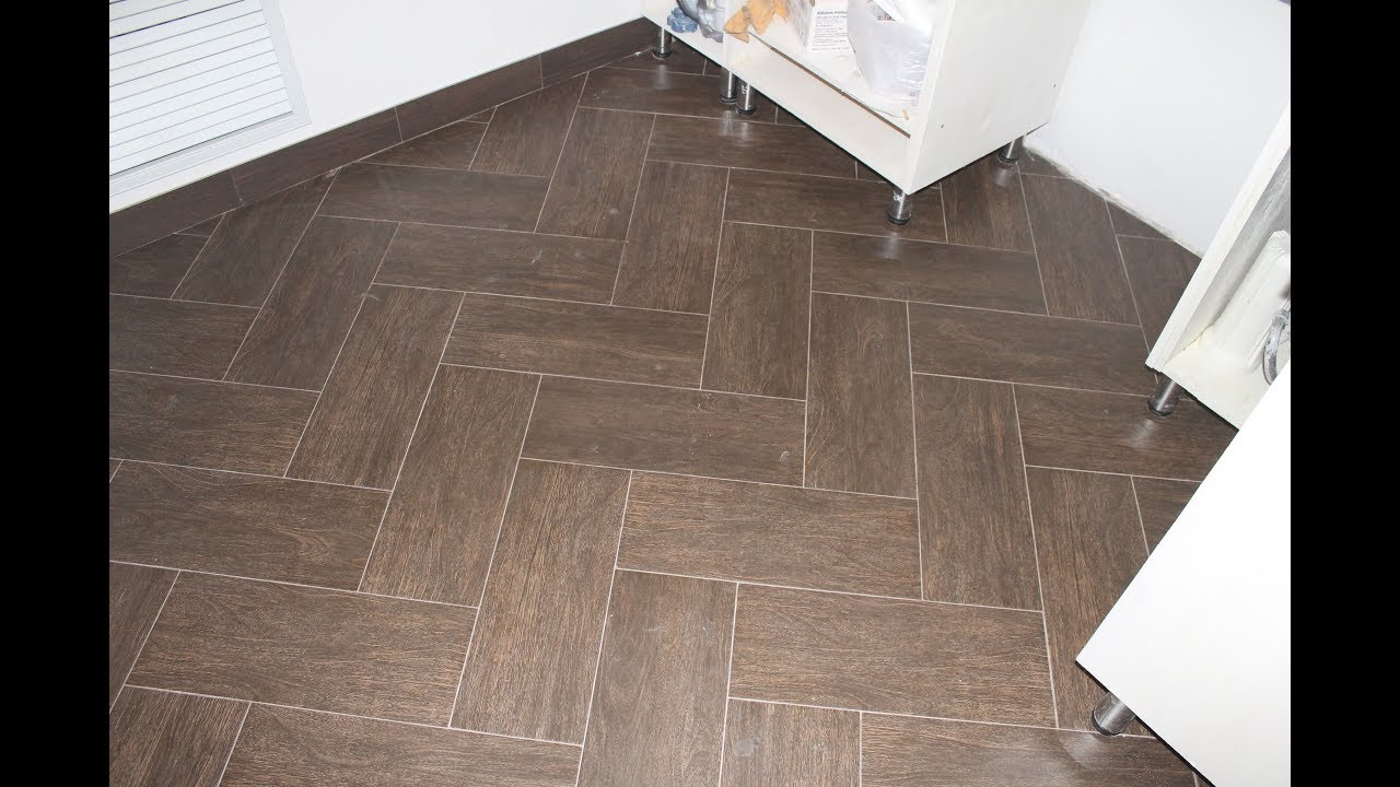 Laying tiles on the floor in a herringbone pattern