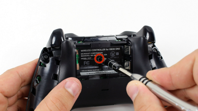 Unscrew the bolt under the gamepad sticker.