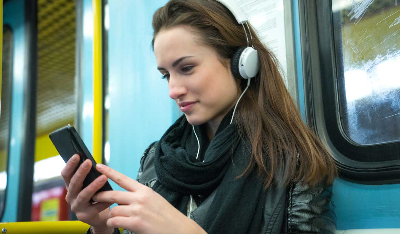 A girl wearing headphones in transport.