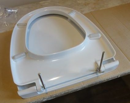 The round ones are attached to the lid, and the elongated ones are attached to the toilet seat.